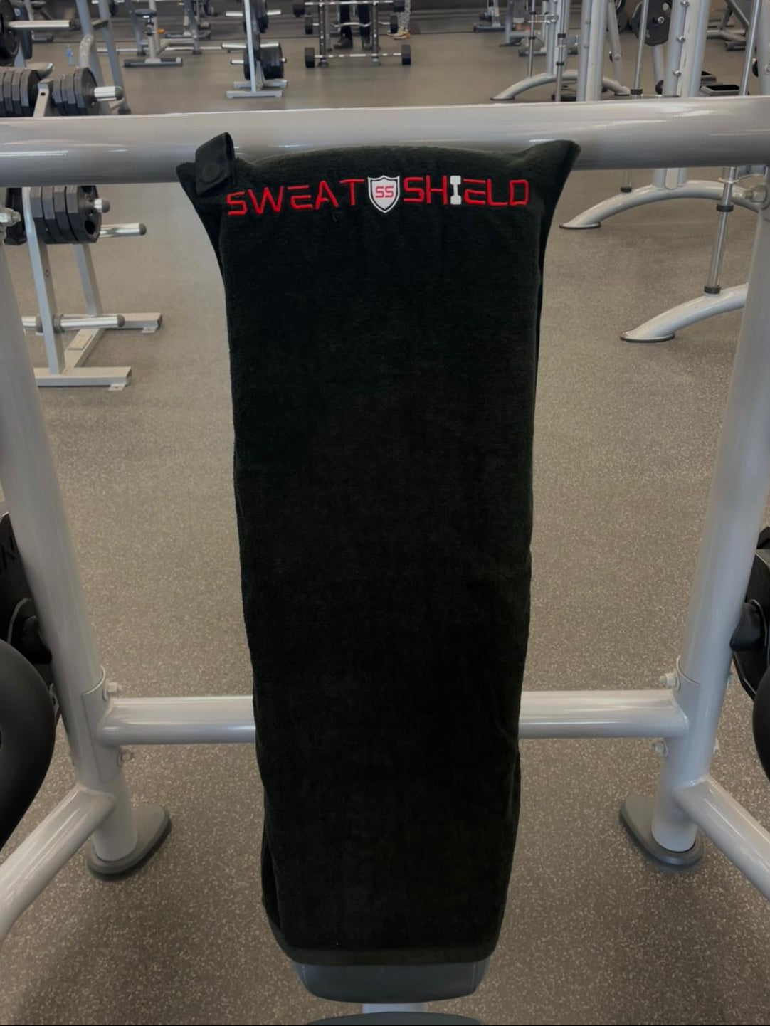 Black sweat shield with 'Sweat Shield' branding on a workout bench.